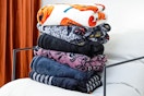 Lifestyle image of folded Way to Celebrate Halloween throw blankets on chair