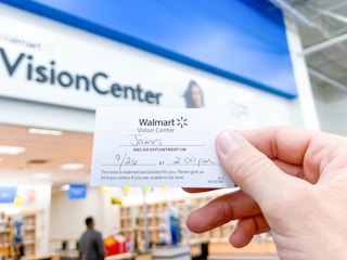 holding up a walmart vision eye center appointment card in store