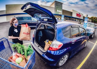 Meijer employee placing Meijer pickup order into car trunk