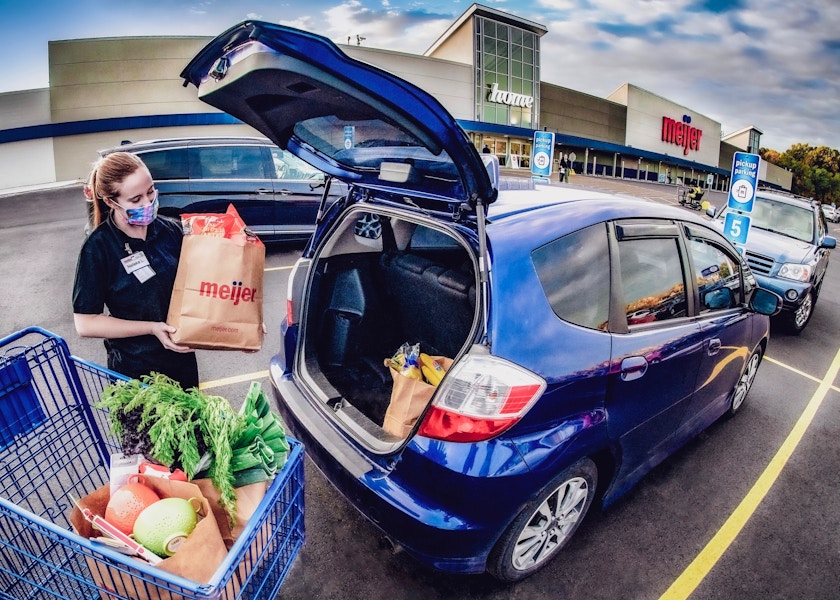 Meijer employee placing Meijer pickup order into car trunk