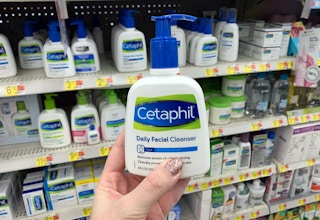 cetaphil daily facial cleanser held up in front of other cetaphil products at walmart