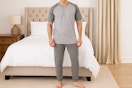 AI image created by ChatGPT of man wearing the Fruit of the Loom sleep set in the color "Grey Heather" in front of a bed