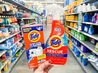 hand holding Tide Washing Machine Cleaner and Rescue Stain Remover spray