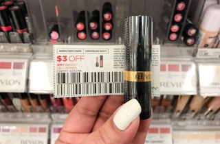 revlon lipstick and coupon held up in front of lipstick display