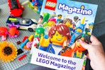lego magazine being held by a table of legos 