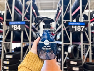 hand holding febreze auto spray in tire aisle at walmart
