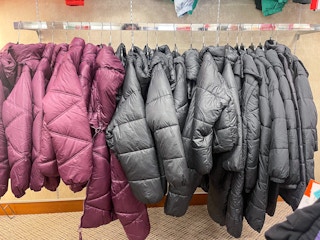 A variety of Arizona Puffer jackets hanging from a store rack.