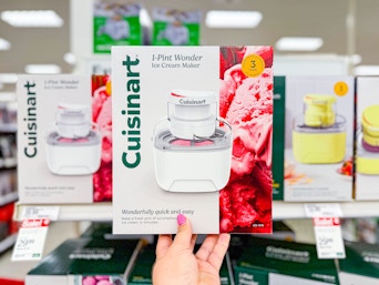 hand holding a cuisinart ice cream maker in front of a target shelf