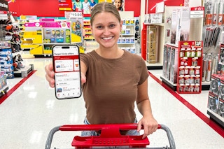 someone holding up a phone displaying Target circle offers and pushing a cart through Target