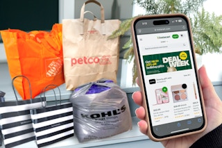 someone holding a phone showing the instacart deal week page online and bags from several retailers