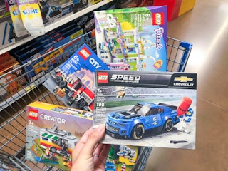 lego set in walmart cart in toy section of store with one set being held up in front