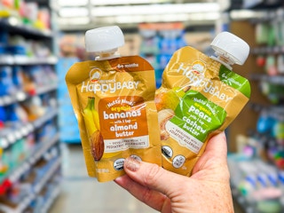 Two Happy Baby Organics food pouches held up in center aisle at Walmart