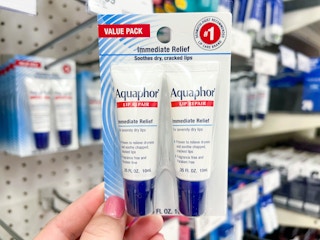 hand holding up two pack of Aquaphor lip balm inside Target
