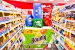 bounty paper towels, persil detergent, cascade dishwasher pods, kleenex, and doritos in an aisle
