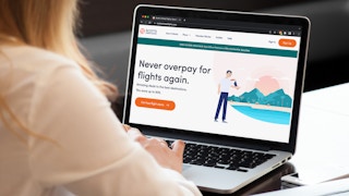 A person using a laptop looking at the Scott's Cheap Flights website