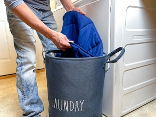 a person pulling a weighted blanket out of a laundry basket