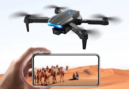 black camera drone with someone holding a phone to watch