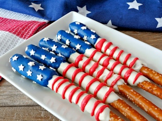 Fourth of July American flag themed pretzel rods on plate with holiday decor