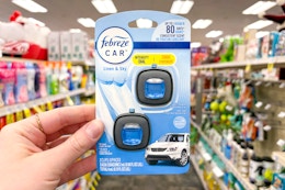person holding a 2-pack of febreze car air freshener vent clips in an aisle