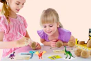 Lifestyle image of a Dinosaur Egg Excavation Kit at Walmart (2 girls playing with it)