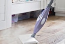 a person using a steam mop on a floor