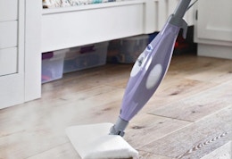 a person using a steam mop on a floor