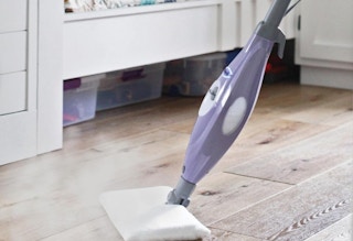 a person using a steam mop on a floor