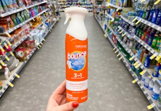 hand holding a bottle of bounce fabric refreshing spray rapid touch up