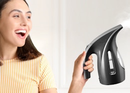 a person holding a clothes steamer