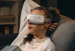 person relaxing with the PureHeal eye massager on her eyes