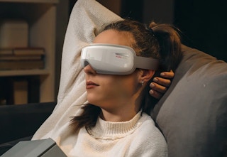 person relaxing with the PureHeal eye massager on her eyes