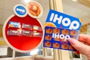 someone holding up two IHOP gift cards inside an IHOP restaurant