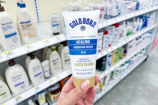 person holding gold bond hand cream