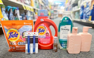 one bottle of Downy Rinse and Refresh in front of shopping cart with bottle of Tide liquid detergent, Monday shampoo and conditioner, ...