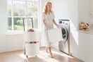 Lifestyle image of the YOUPIS 3-Tier Laundry Hamper Sorter (basket carried by woman in laundry room setting)