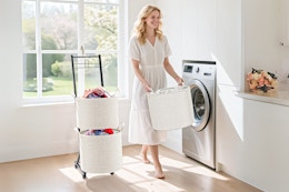 Lifestyle image of the YOUPIS 3-Tier Laundry Hamper Sorter (basket carried by woman in laundry room setting)