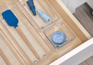 a drawer with clear organizers and blue utensils in each