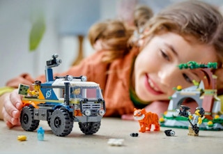 childing playing with the Lego City Jungle truck