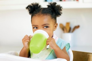 a baby drinking from a munchkin sippy cup