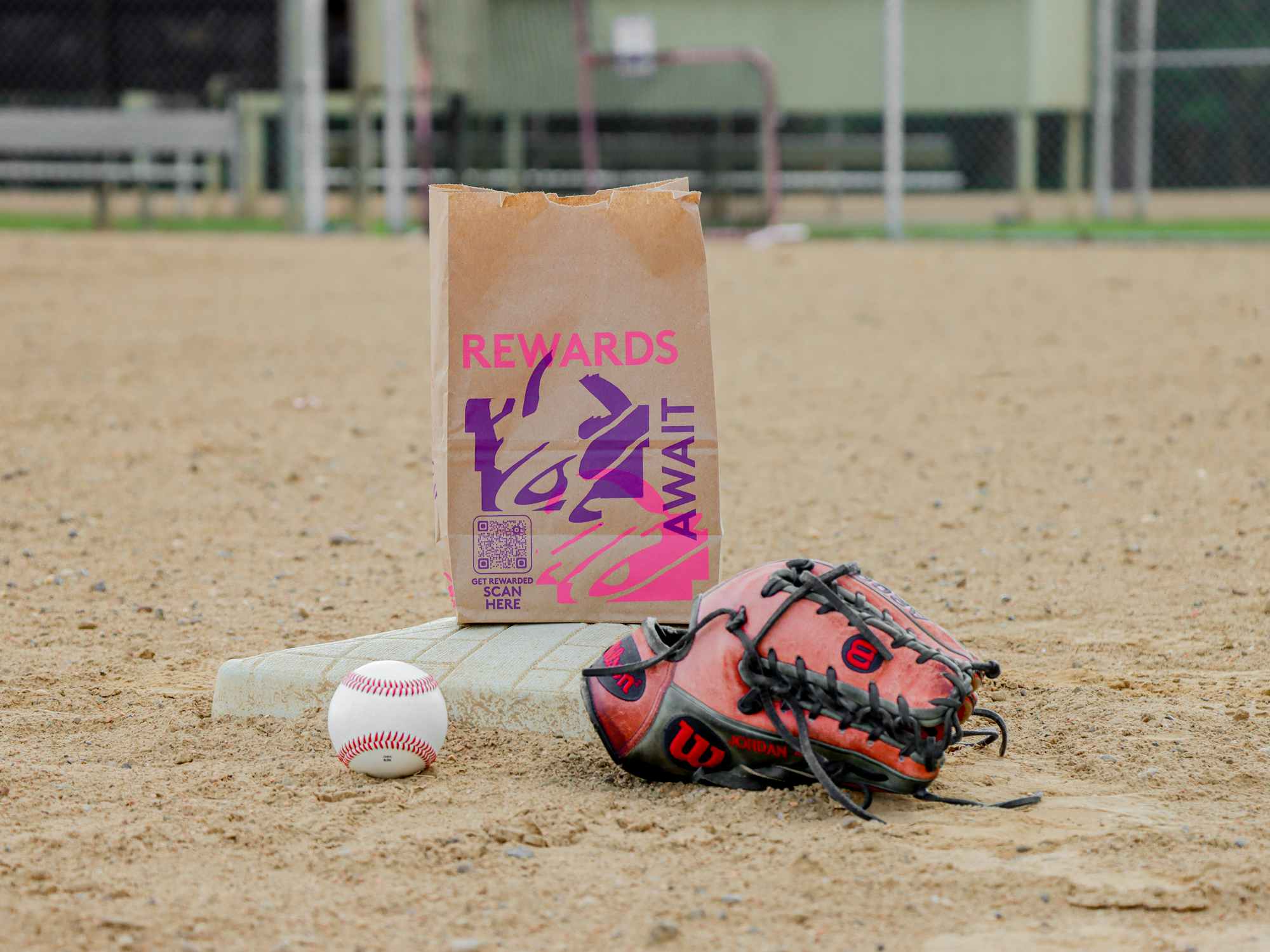 a taco bell bag, baseball glove, and a baseball sitting on a base