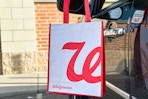 a walgreens reusable shopping bag next to a car door outside of a store