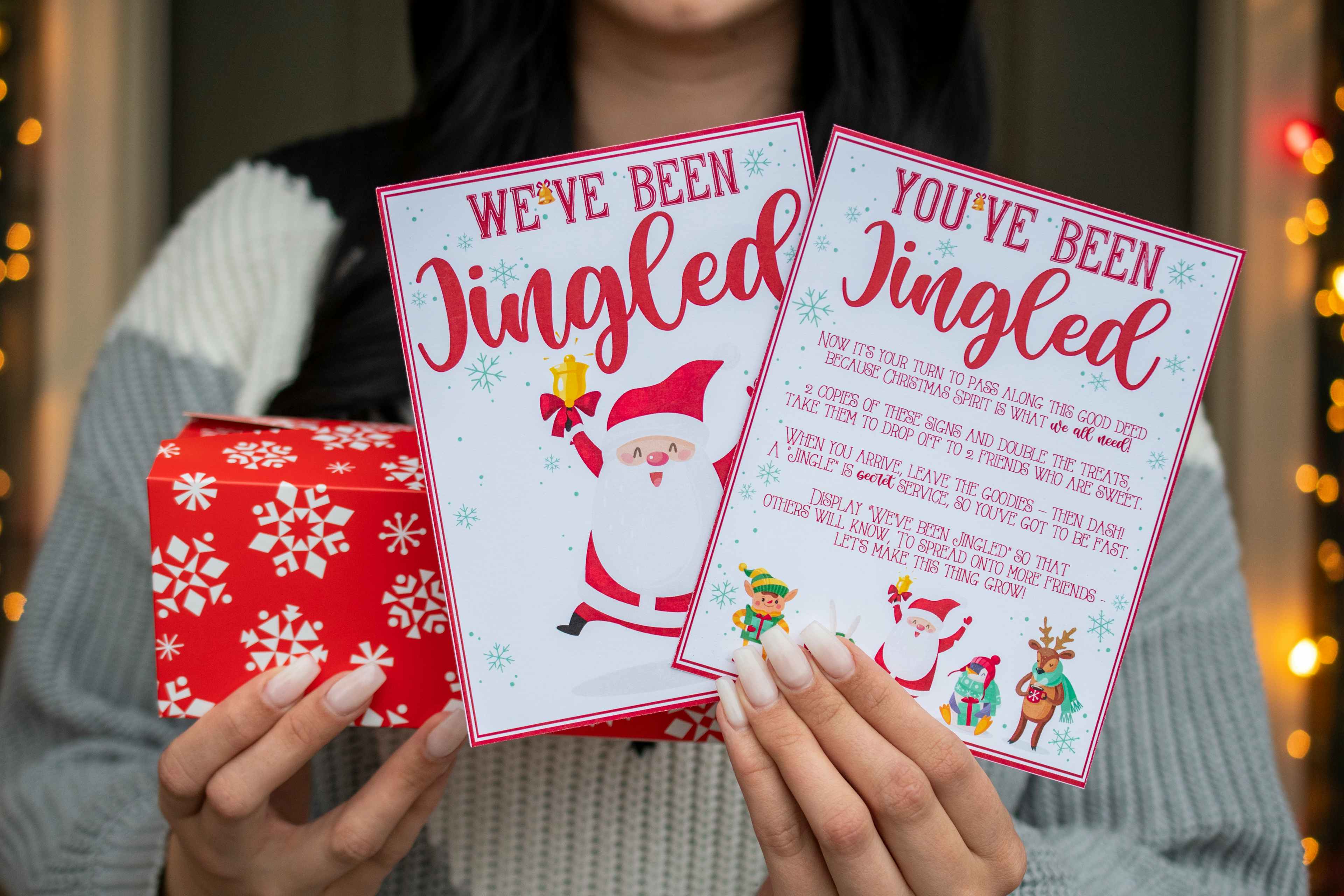 Someone holding a wrapped present and two cards, one saying "we've been jingled" and the other saying, "you've been jingled" with an expl...