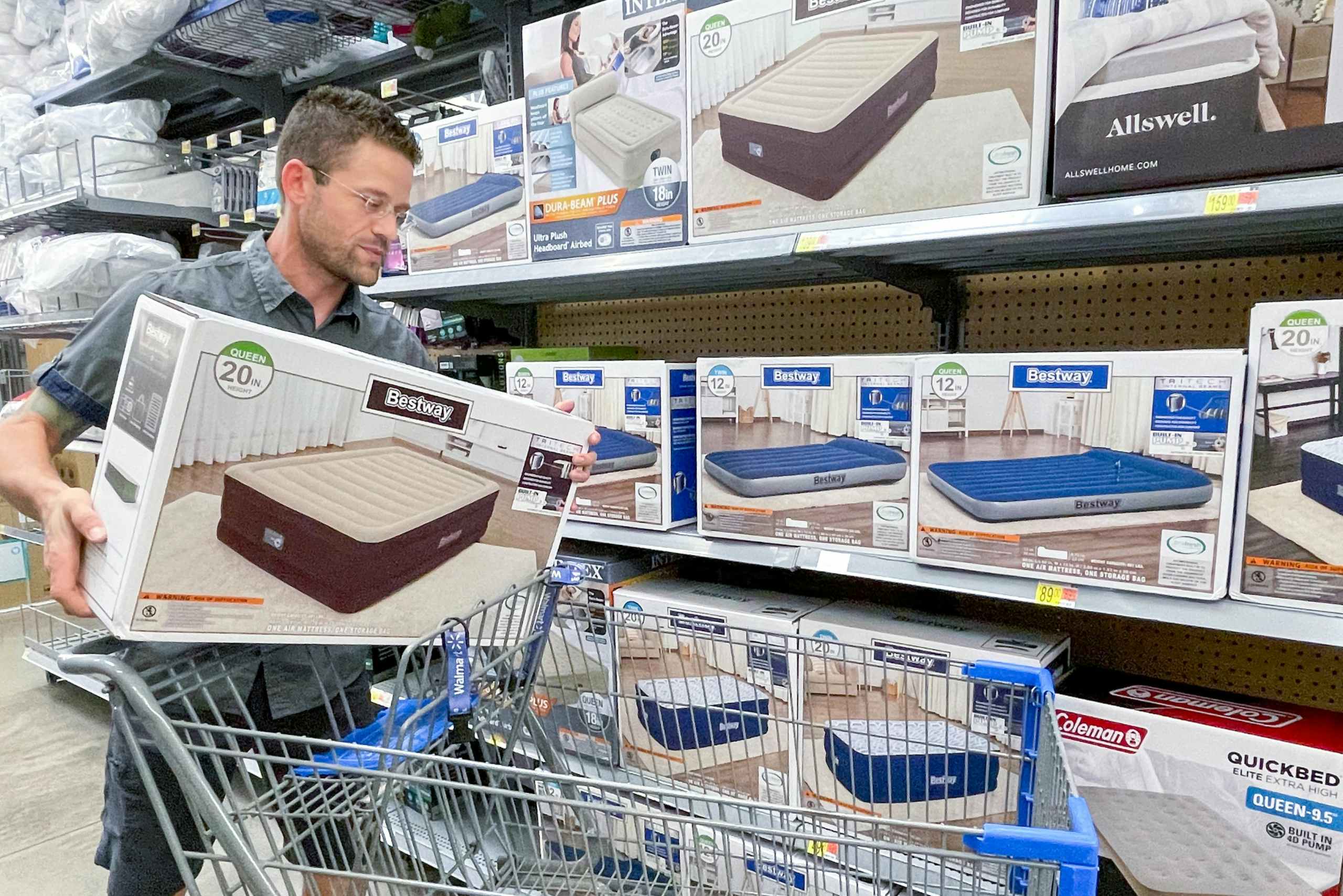 man putting a air mattress box in walmart cart