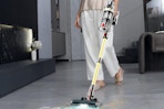 Woman using the Linkifly Cordless Vacuum Cleaner on hardwood floors.