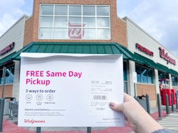 a person holding a photo prints package in hand in front of walgreens