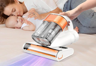 a person using a mattress vacuum next to a mom and baby