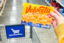 hand holding a box of velveeta shells and cheese