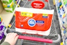 person pushing a cart with a pack of toilet paper in it