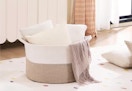 large rope basket with throw pillows sitting inside