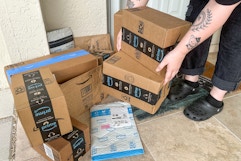 Someone picking up Amazon prime boxes on the porch